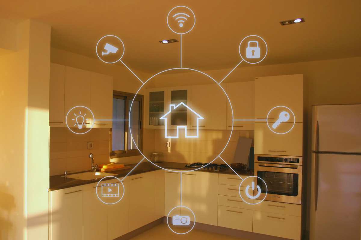 Cucina sullo sfondo e sopra di essa l'immagine virtuale di una casa con tanti rami sui vari settori della domotica